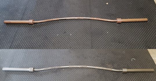 A pair of barbells on a black mat.