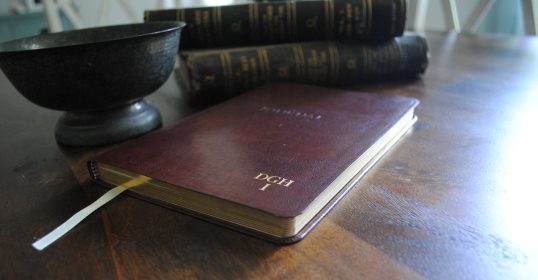 A man book is placed on a table next to a reservoir.