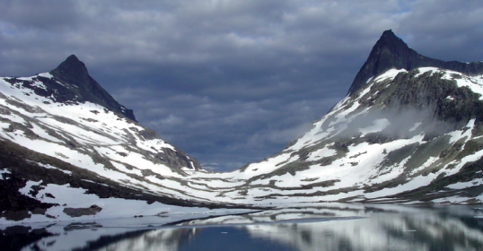 A lake nestled between snow-covered mountains, offering a serene escape.