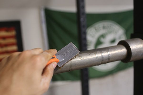 Oiling barbell with brush.