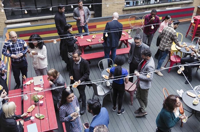 A group of people enjoying the social life on a rooftop.