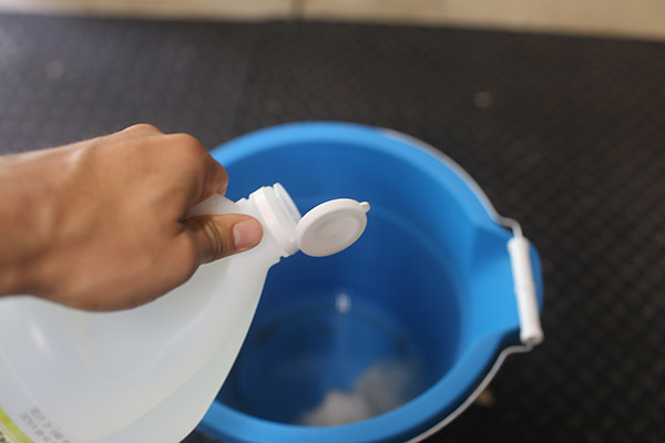 Filling bucket with vinegar.