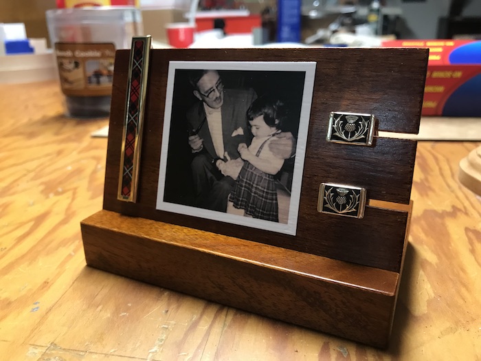 Vintage photo and cuflink on a wooden stand.