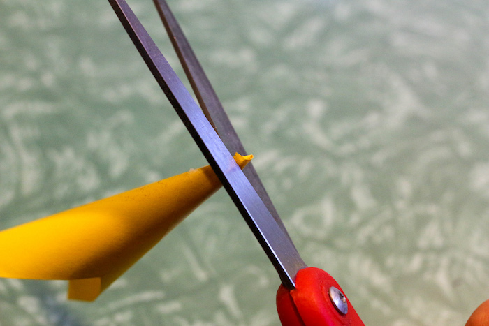 Trimming tip of cone with scissor.