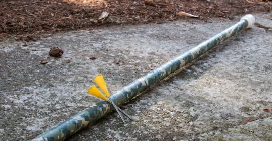 A PVC pipe with a yellow arrow protruding from it.