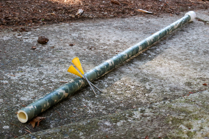 A PVC pipe with a yellow arrow protruding from it.