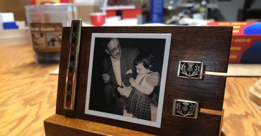 A wooden photo holder with a picture of a man and a woman, perfect for displaying your heritage.