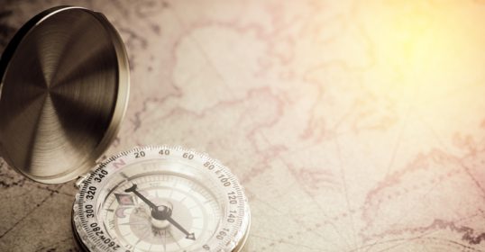 An old compass on a historic map for navigation enthusiasts.