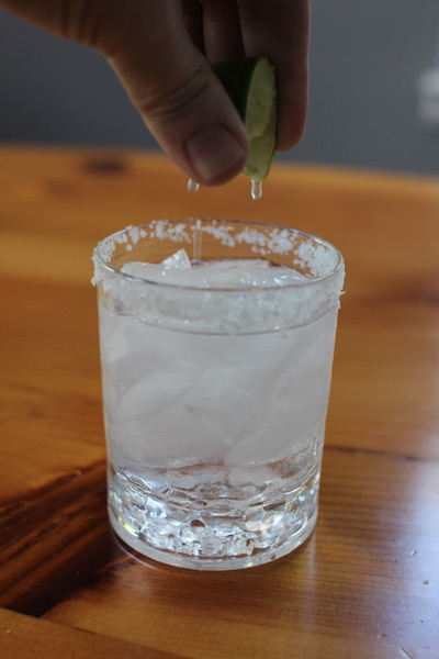 Squeezing lemon in the glass.