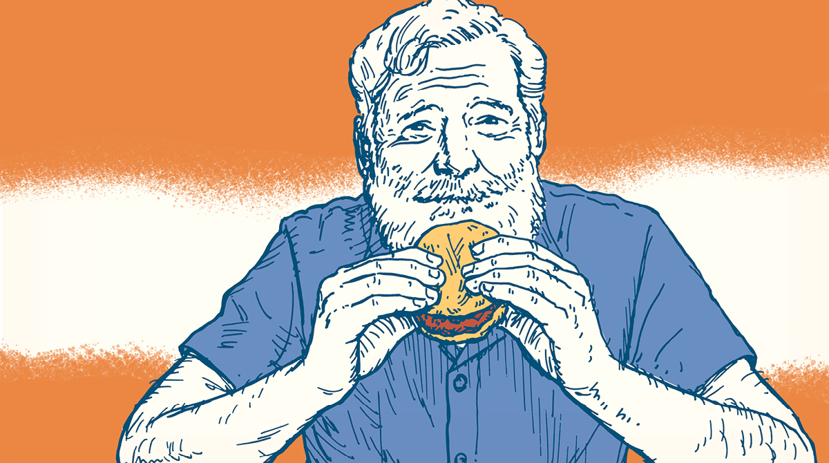 Ernest Hemingway, a man with a beard, enjoying his favorite hamburger.