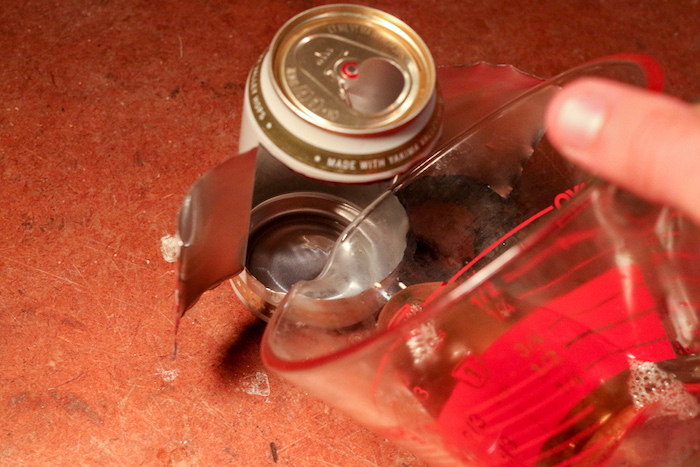 Step 6: Pouring grease into bottom of a Can.