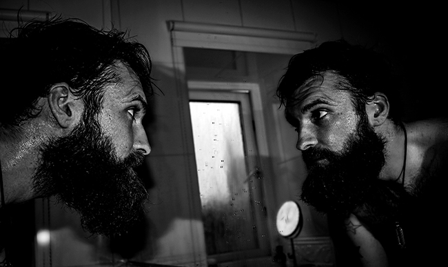 On a Sunday Fireside, a man with a beard gazes at his Best Self in the mirror.