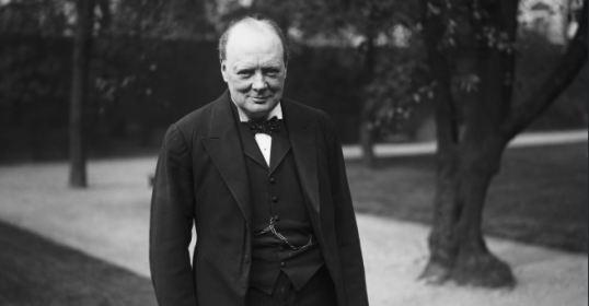 A black and white photo of a man in a suit, reminiscent of Winston Churchill.