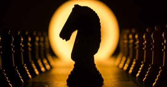 A silhouette of a horse on a chess board symbolizes strategic planning and calculated moves towards fulfillment.