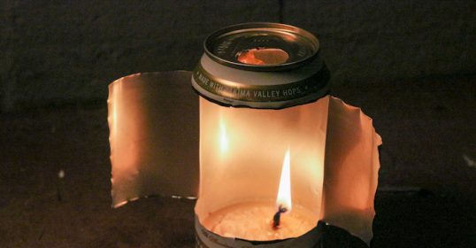 A candle is lit in an aluminum can.