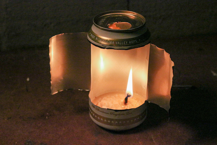 A candle is lit in an aluminum can.