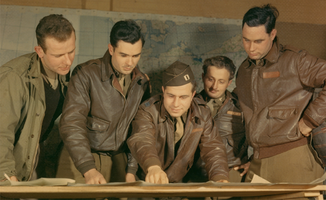 A group of men examining a map.
