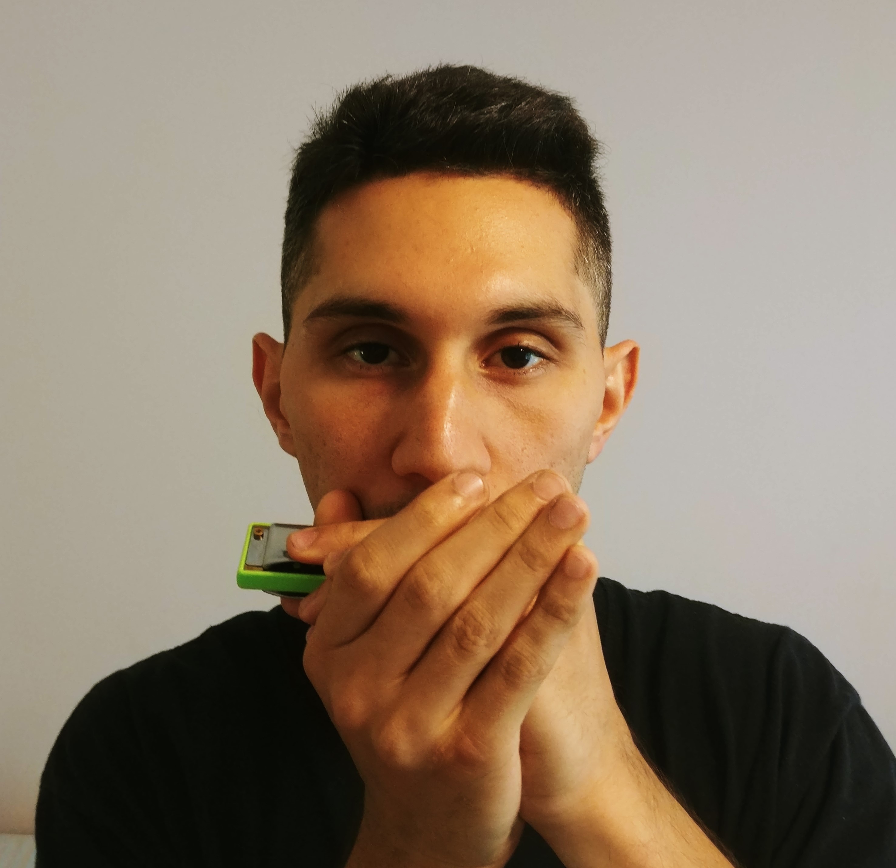 A boy holding the harmonica.