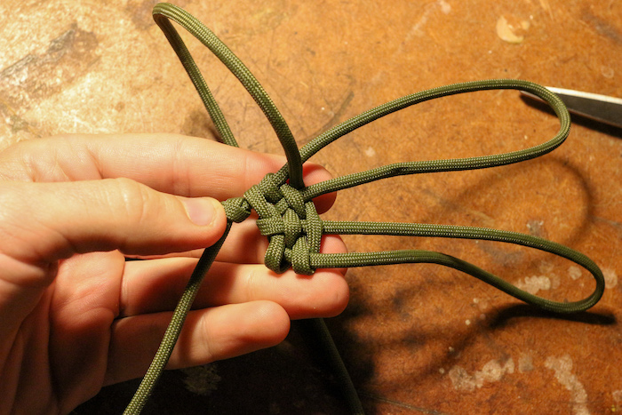 Step 6: Making a few passes, pull your weaves tight against your original overhand knot. This will keep your pouch weave tight, and make it easier to hold everything together.