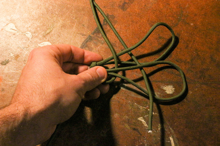 Step 5: Take the long end and pass it back through the loops, alternating your weave over and under each piece of paracord as you go. Once you've pulled the paracord through your first weave, start weaving back, following the over-under method.