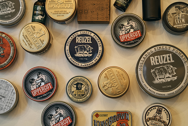 On the wall, various tins of beard products are showcased for customers to choose from.