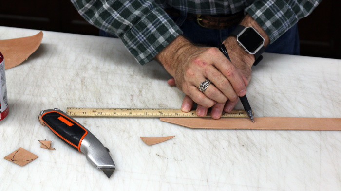 Measurement of leather strip with the help of ruler is shown.