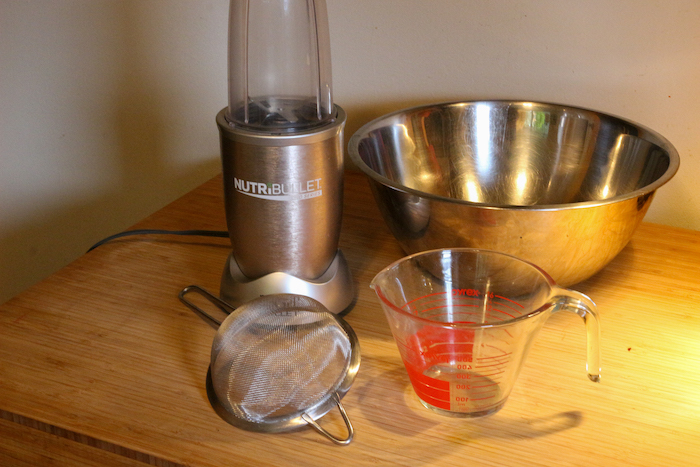 Blender, Mesh strainer, Mixing bowl and Measuring cup being displayed on the table.