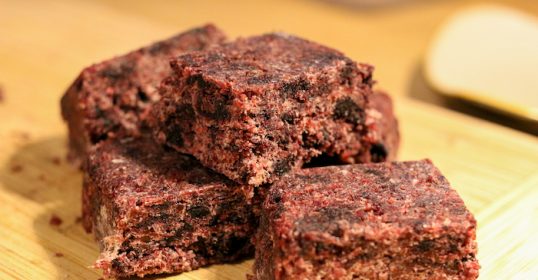 A stack of brownies on a cutting board prepared from a recipe.