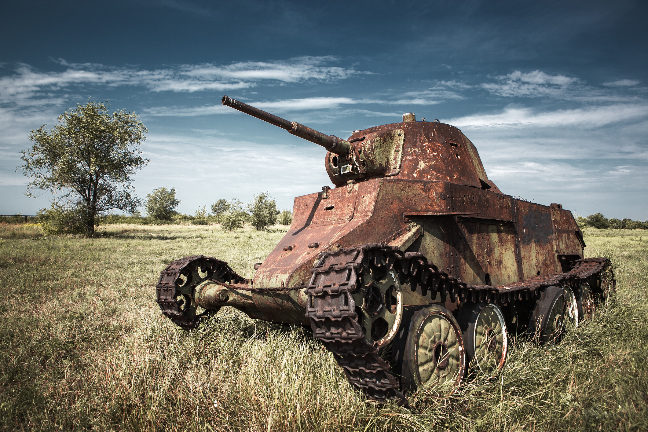 A rusty tank from the Last War sits abandoned in a field.