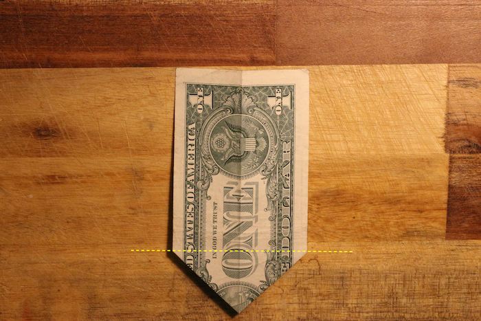 Flip your bill over and arrange it so the pointy side is down. Fold the point up along the indicated yellow line.