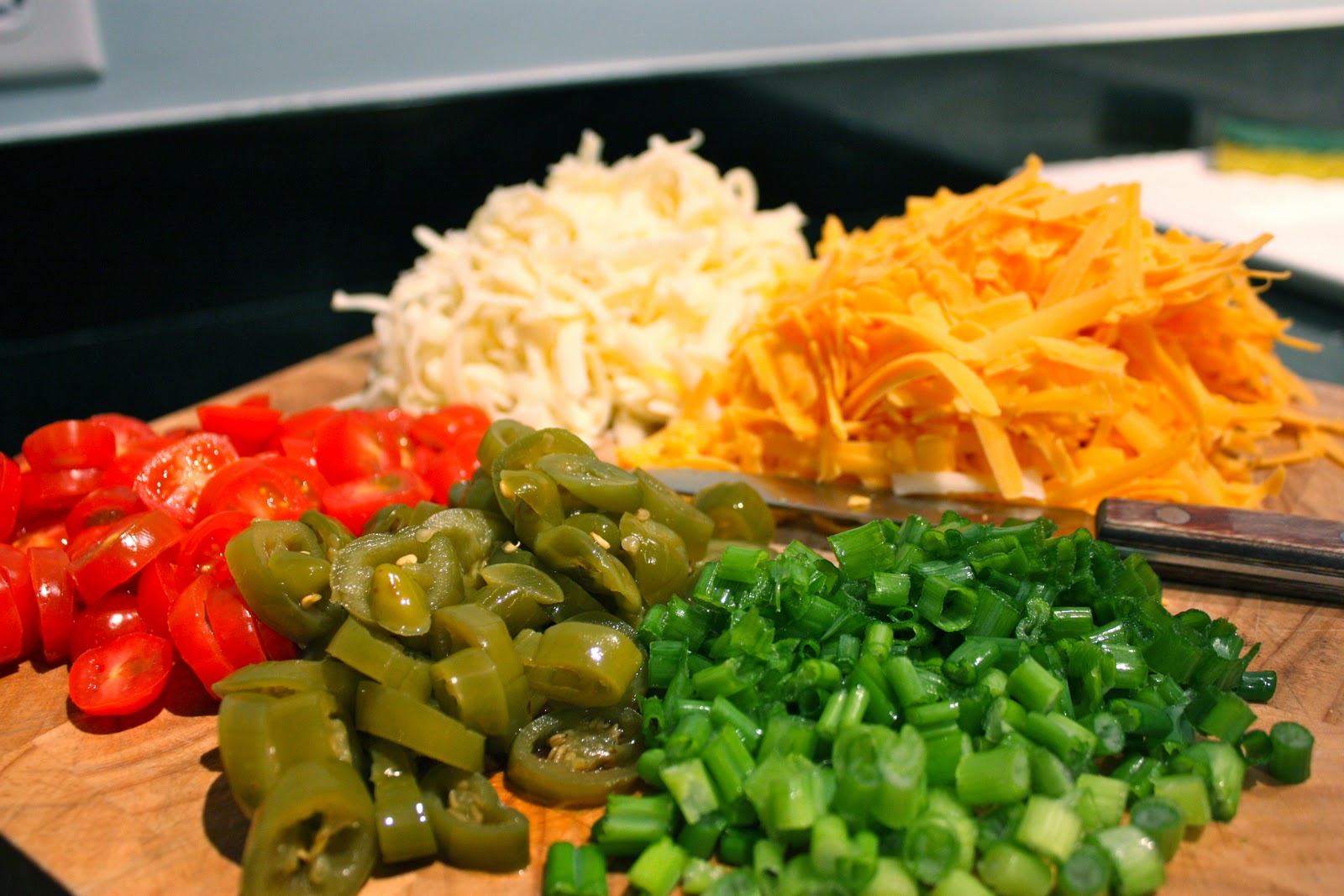 Cheese and different vegetables on chopping board. 