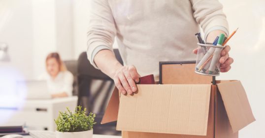 Learn how to transition careers by observing as a man opens a cardboard box in an office.