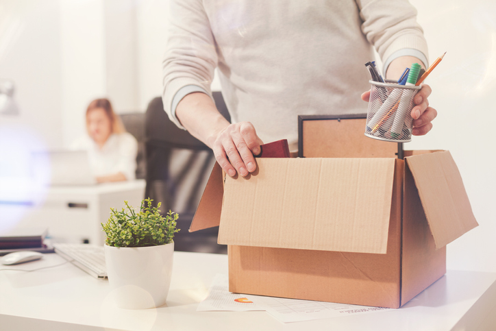 Learn how to transition careers by observing as a man opens a cardboard box in an office.