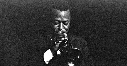 A black and white photo of a man playing a trumpet, perfect for those who enjoy jazz music.