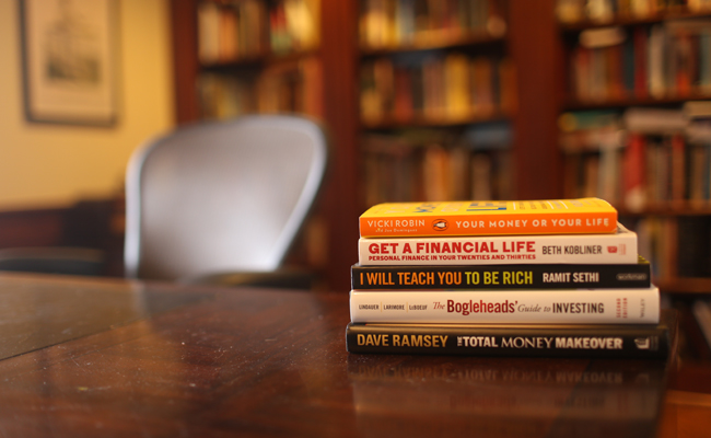 A stack of books on a wooden table for education purposes.