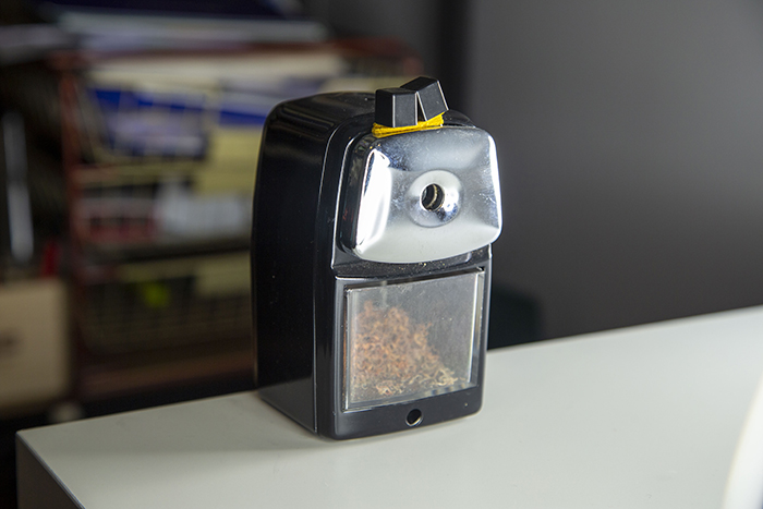 A black and yellow cigarette lighter sits on a table.