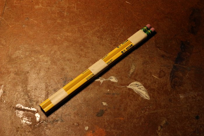 Two pencils attached with each other with the help of tape.