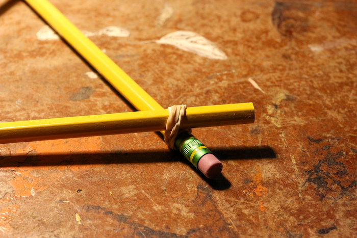 Two pencils attached with rubber band at one end.