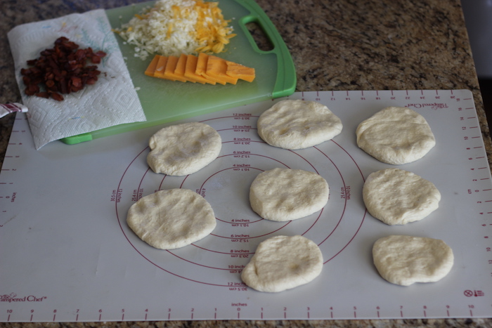 Shaped dough along with cheese and bacon is placed. 