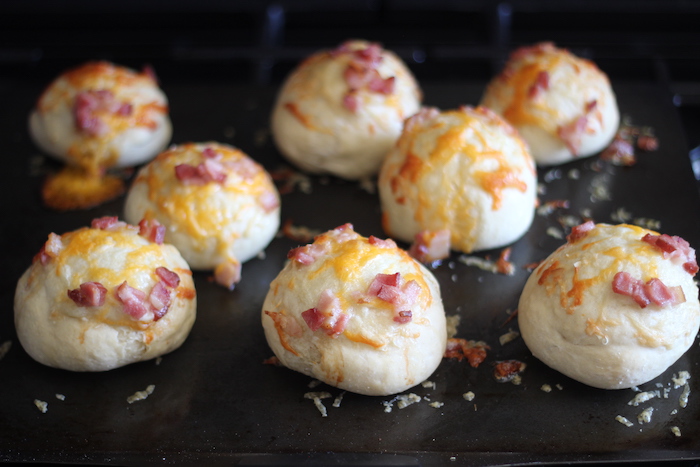 Eight Cheesy bacon rolls displayed.