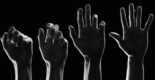 A black and white image of a group of hands, perfect for a podcast cover or to ask questions about.