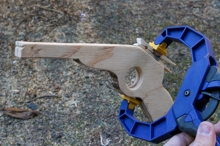 Clamping the clothespin onto the rear of the rubber band gun.
