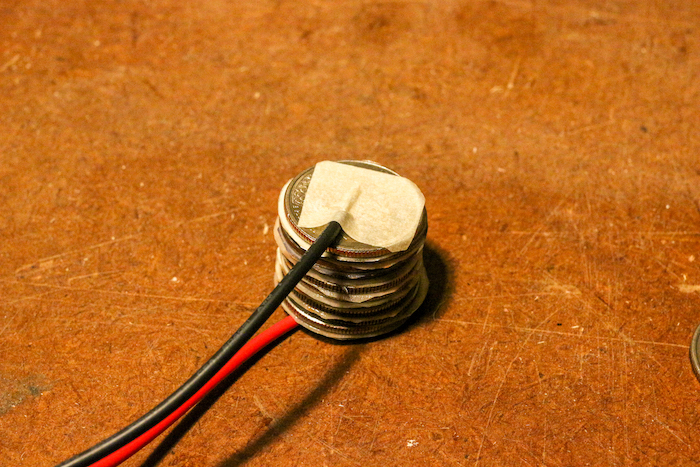 Stack of quarters and foils attached to the wires from both ends. 