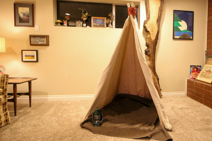 A teepee crafted by kids sits in the living room.