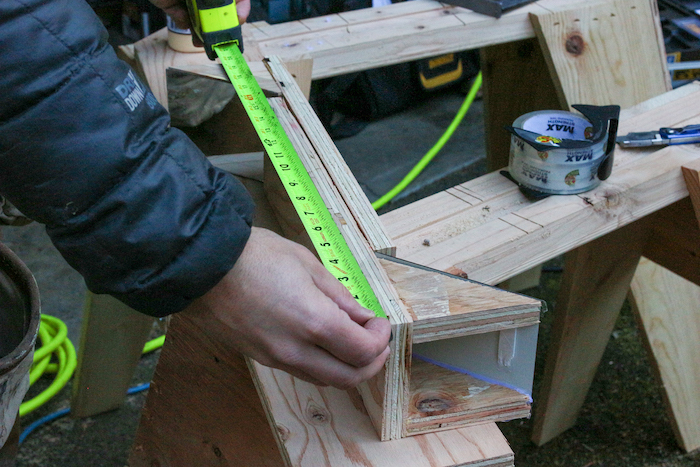 Side of plywood is being measured. 