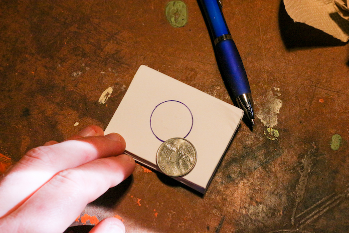 Making quarter on paper with the help of pen and quarter.