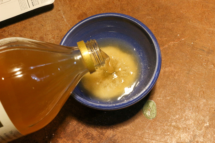 Mixture of vinegar and salt being added to a bowl. 