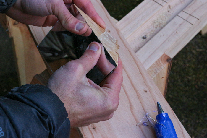 Mirror being attached to plywood. 