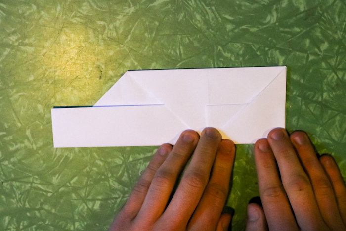 Folding the sides in to create a square edge to the paper.