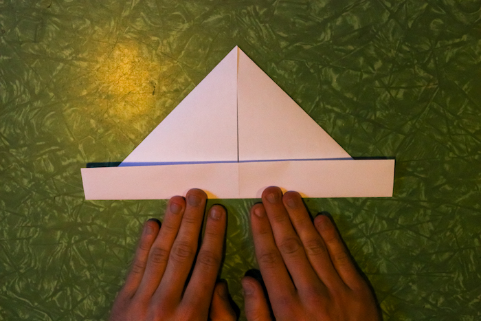 Making boat from paper by hands.